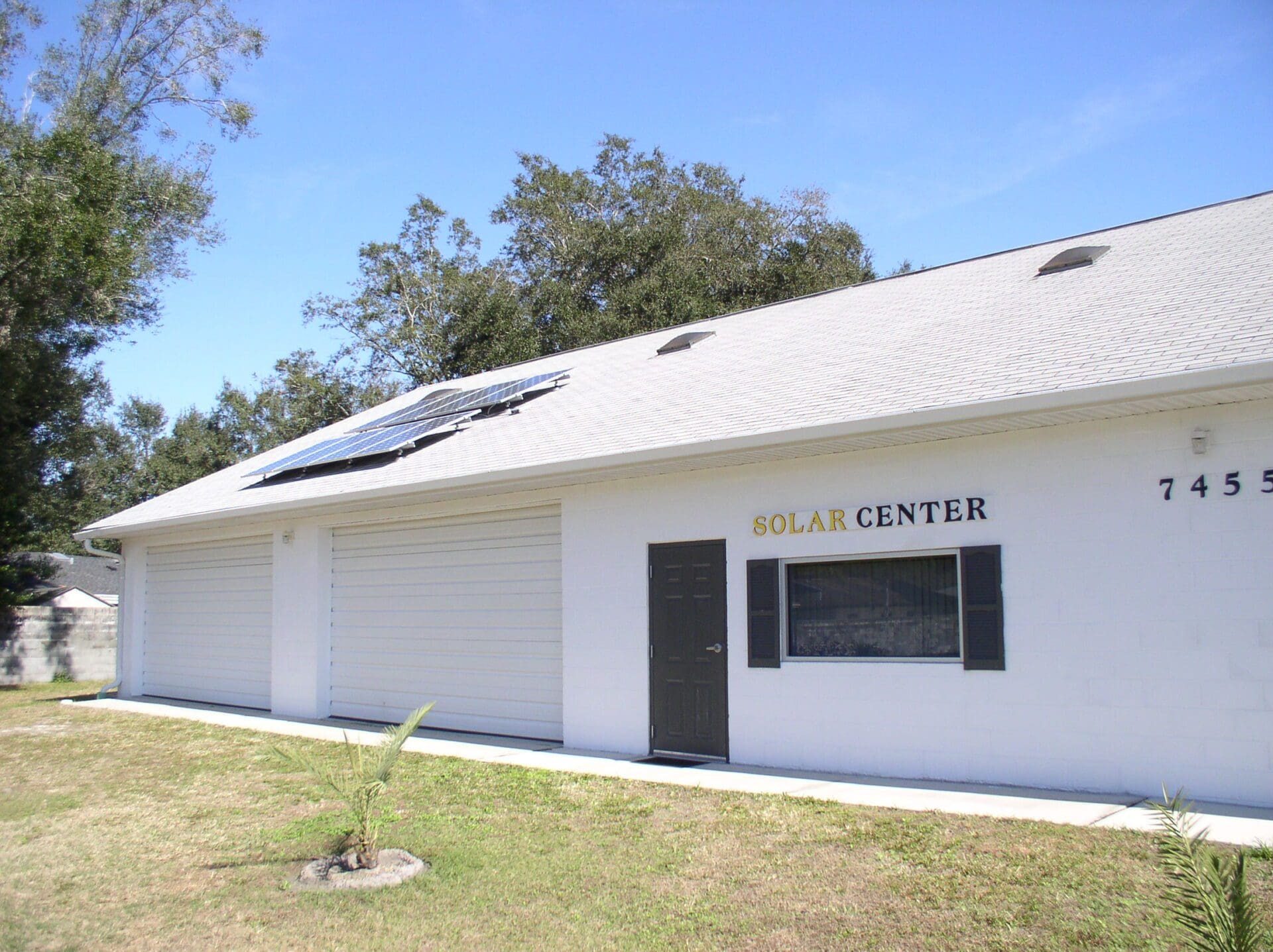 A white building with a solar panel on the roof.